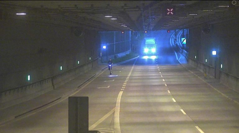Ludzie w tunelu DTŚ. Jedni na piechotę, inni rowerem i hulajnogą