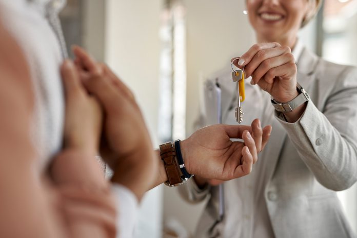closeup couple receiving keys their new apartment from real estate agent
