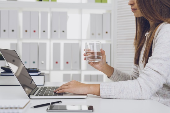 Girl with glass of water typing Girl with glass of water typing